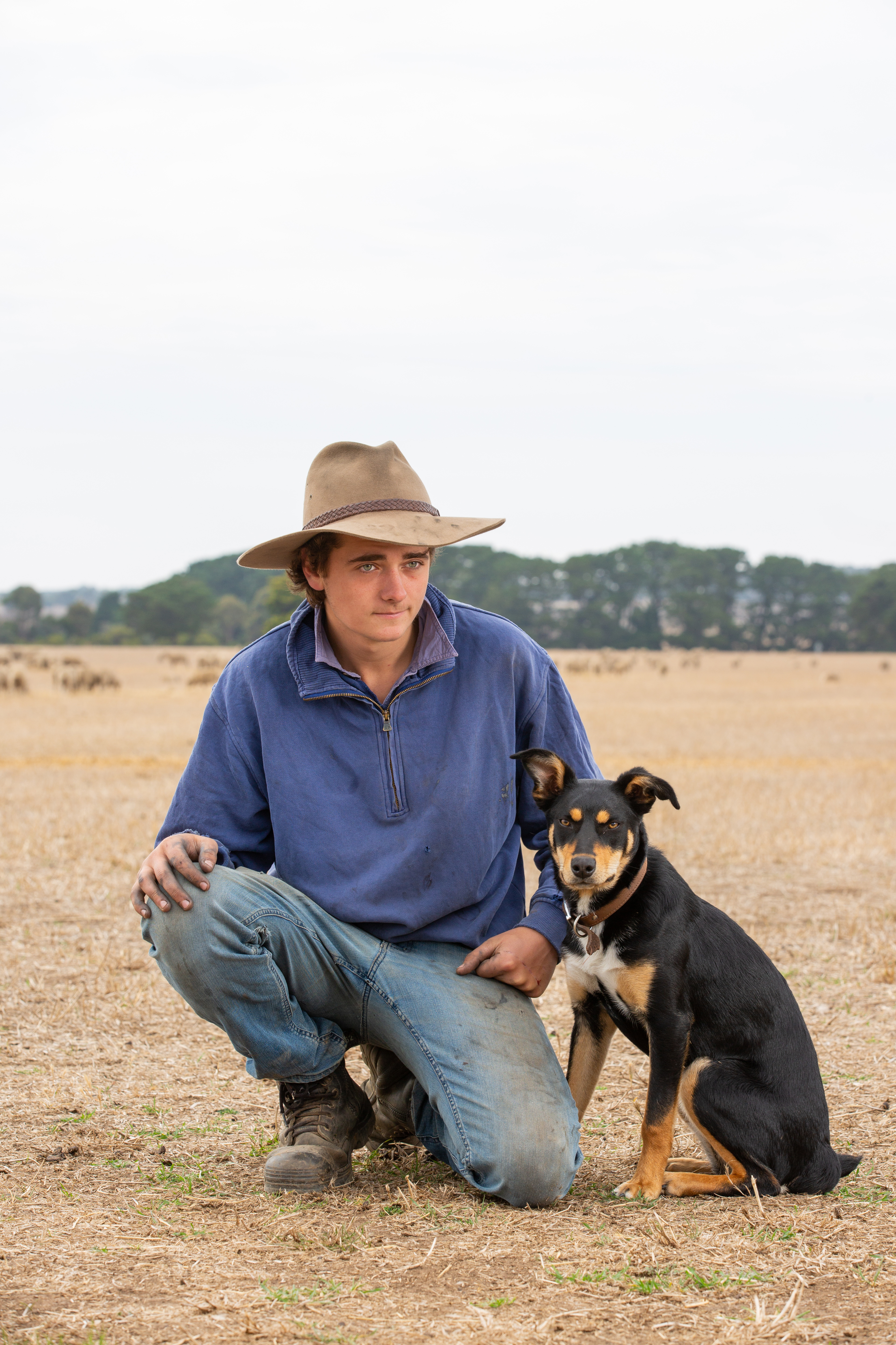 Noah kneeling next to a farm dog